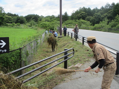 大勢で除草作業をしている写真