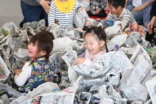 新聞紙で遊ぶ子ども